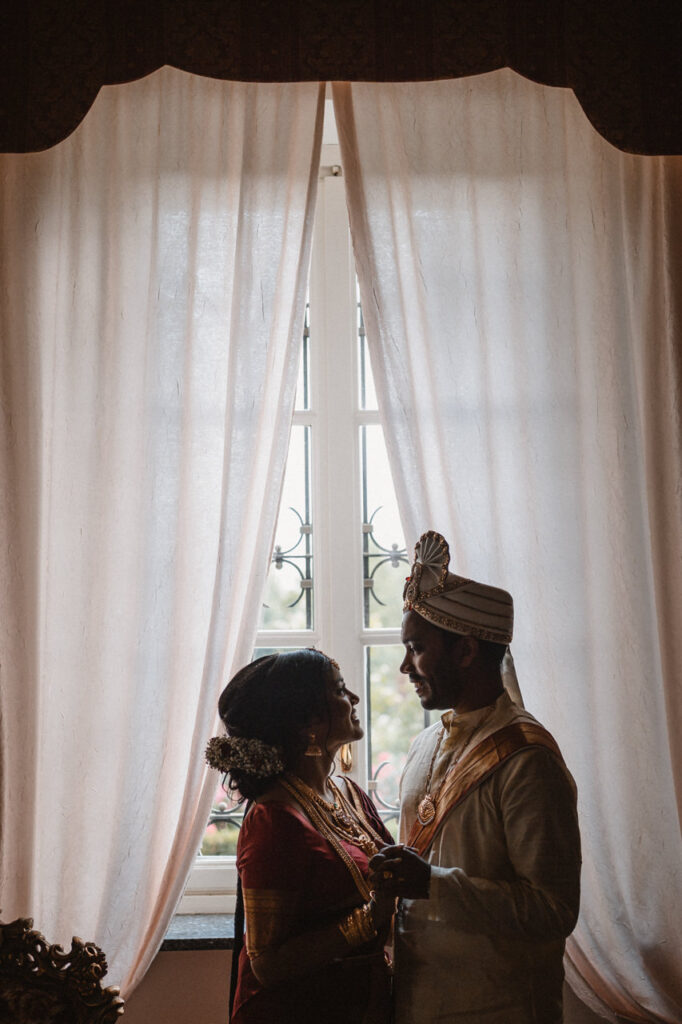 Bride adjusting her earring while looking in a mirror.