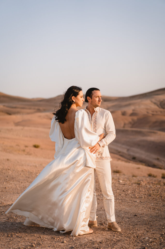 Bride and groom holding hands with their wedding rings visible.