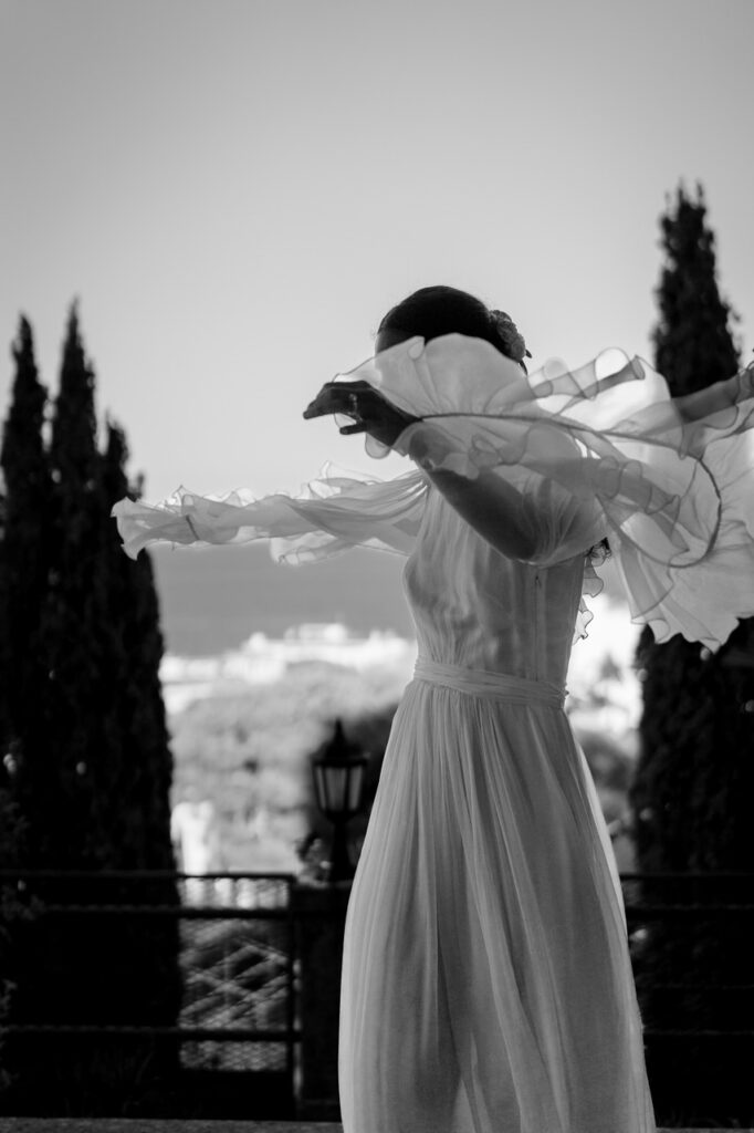 Bride walking down a staircase, dress flowing behind her.