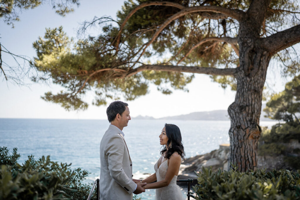 Couple standing on a bridge, sharing a kiss.