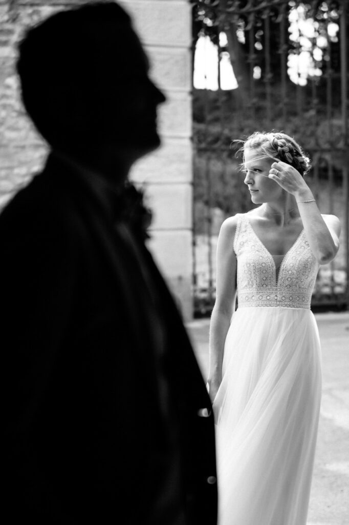 Couple sharing a kiss in front of a grand entrance.