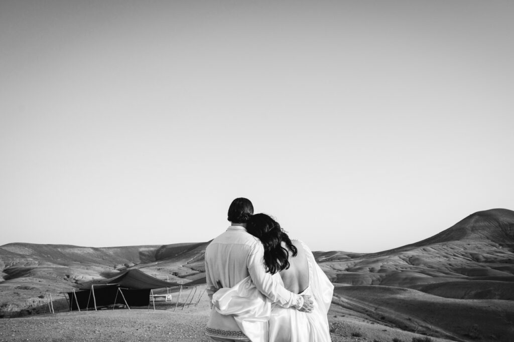 Couple standing in front of a castle, sharing a kiss.