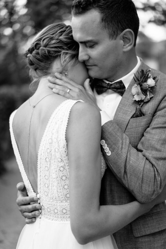 Couple sharing a kiss at a vineyard.